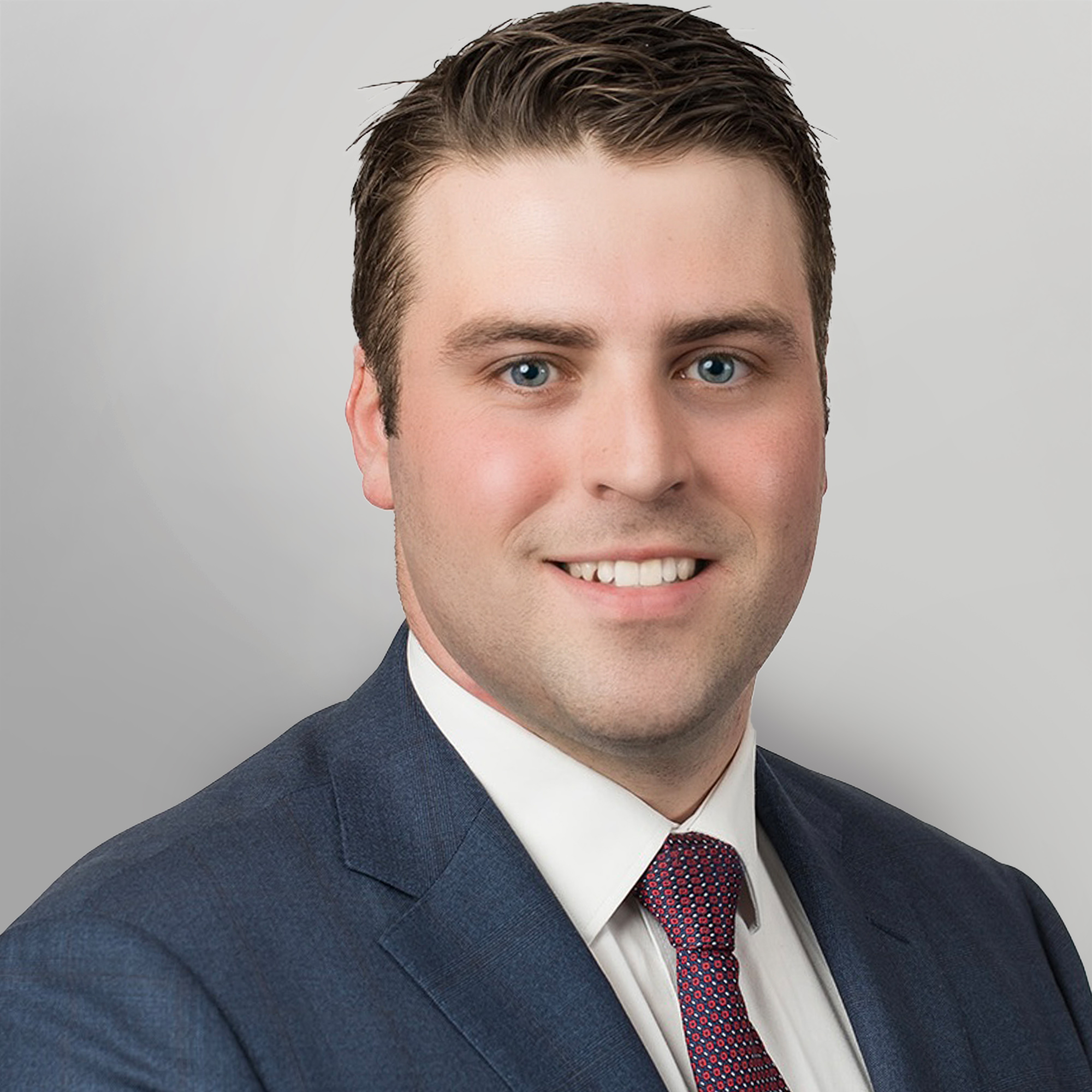 Professional headshot of Kurt Gallacher in a blue suit and red tie.